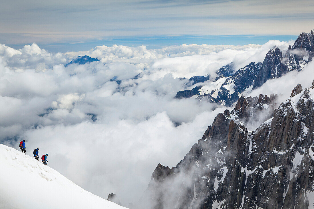 Mountain climbers departing Aiguille du midi, surrounded by French Alps summits; Chamonix-Mont-Blanc, Haute-Savoie, France