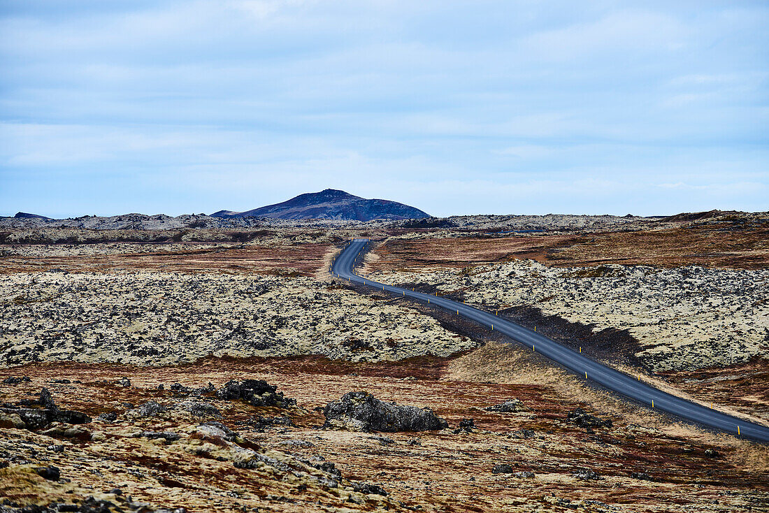 A Highway Runs Across A Barren Landscape With A Mountain In The Distance, Snaefellsnes Peninsula; Iceland