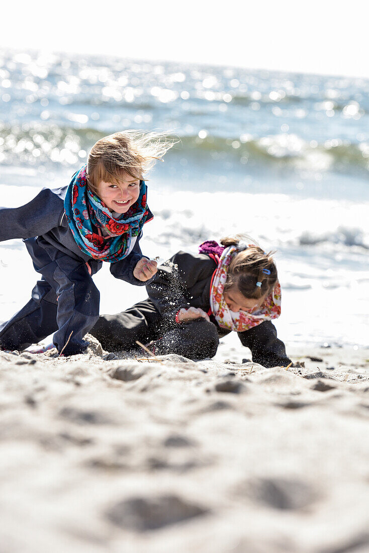 Kids playing at the beach in winter on Baltic Sea, Kellenhusen,  Schleswig Holstein, Germany