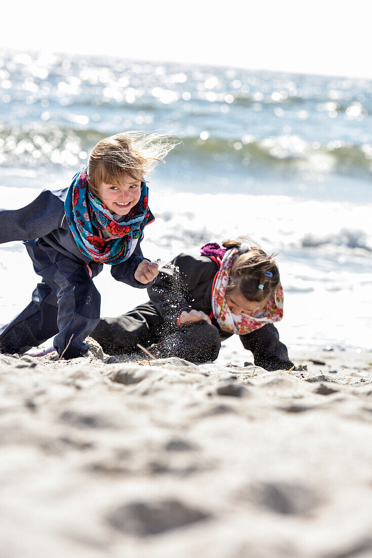 Kinder spielen am Strand im Winter an der Ostsee, Kellenhusen, Schleswig Holstein, Deutschland