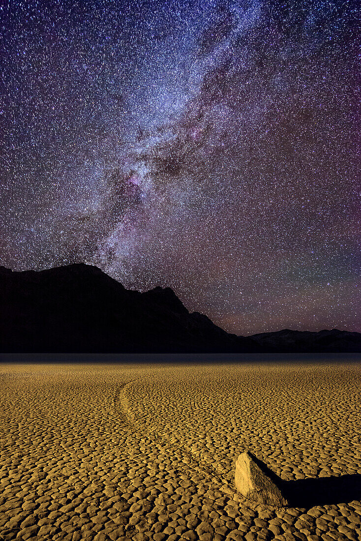Sailing stone with race track in clay pan with nightsky, Racetrack Playa, Death Valley National Park, California, USA