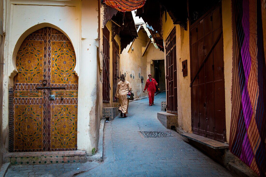 Fes, Morocco, North Africa. Passers in the narrow streets of the medina.
