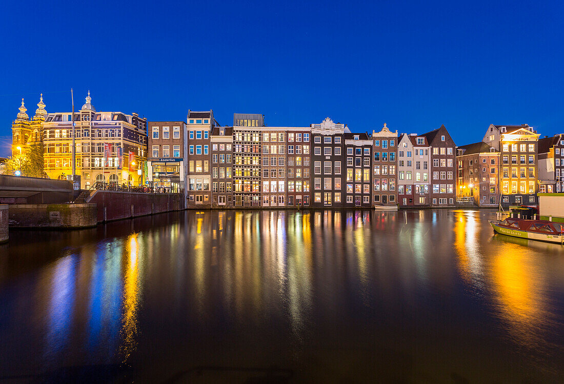 Amsterdam, Netherlands. Cityscape with lights on, reflecting on a canal at night