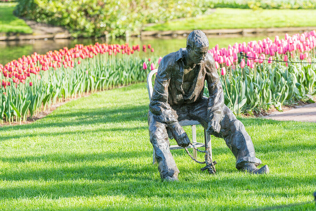 Statue of a man and tulips at Keukenhof Gardens. Lisse, South Holland province, Netherlands.