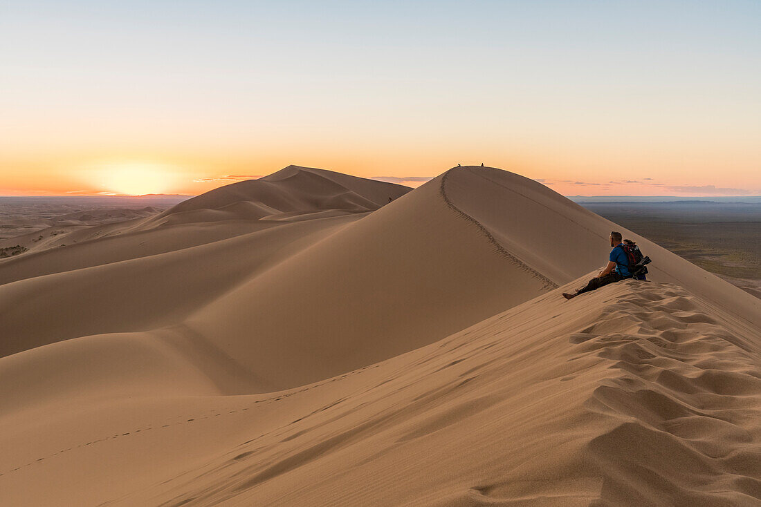 Man watching the sunset in Gobi Gurvan Saikhan National Park, Sevrei district, South Gobi province, Mongolia