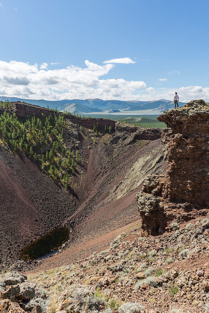 Man gazing at Khorgo volcano crater. Tariat district, North Hangay province, Mongolia.