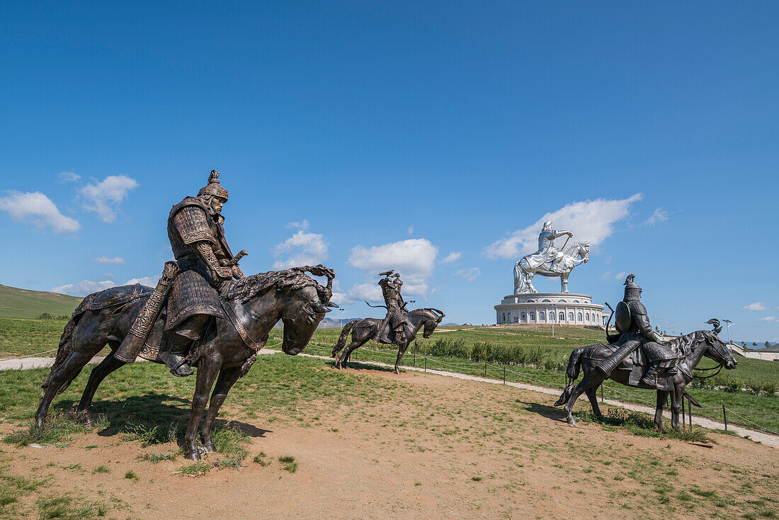 Statues of the Mongolian Empire warriors and Genghis Khan Statue Complex in the background. Erdene, Tov province, Mongolia.