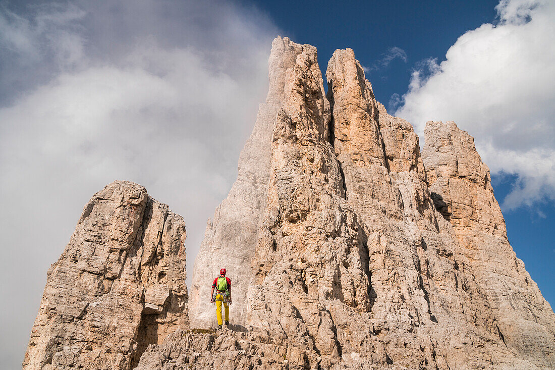 A climber admiring the rocks of spigolo Delago. Torri del Vajolet, Val di Fassa, Trentino, Italy