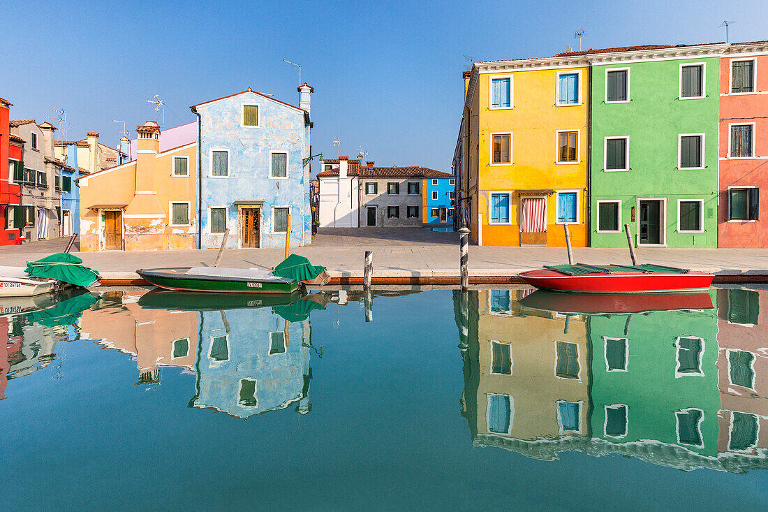 colorful houses in Burano reflected in the water canal, Venice, Veneto, Italy