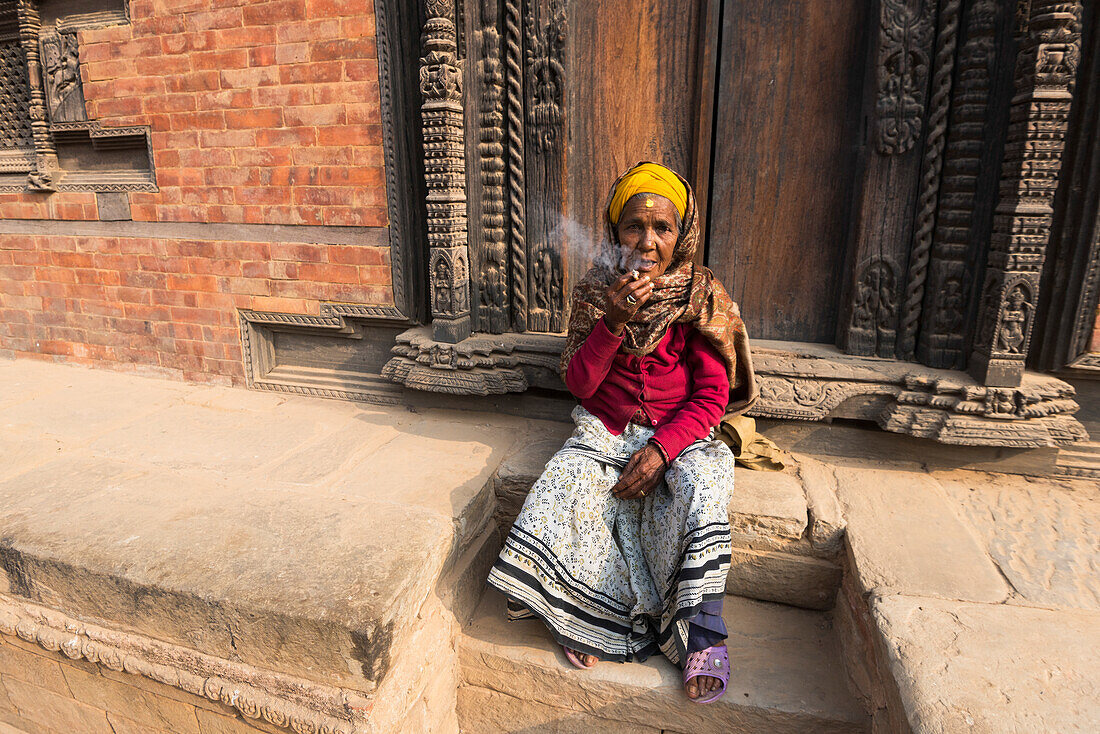 Patan durbar square,Katmandu,Nepal Woman smokes in the Patan square