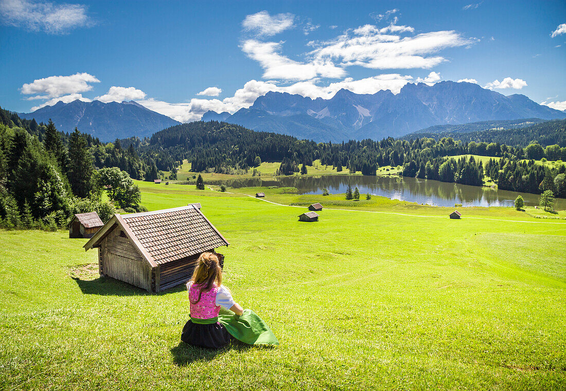 A girl in typical dress looks at the Geroldsee, Gerold, Garmisch Partenkirchen, Bayern, Germany