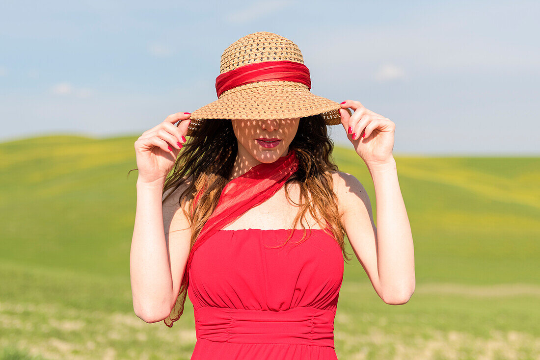 San Quirico d'Orcia, Orcia valley, Siena, Tuscany, Italy. A young woman with straw hat