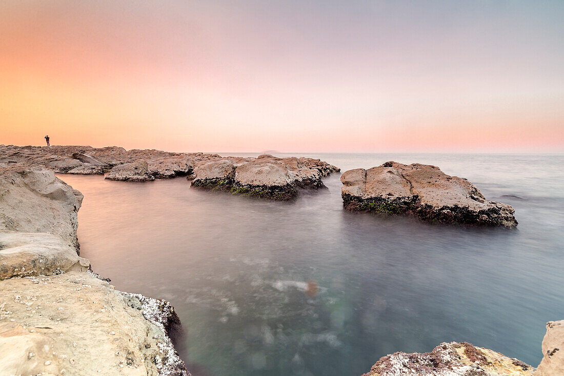 Boy over the rocks in Passetto coast at sunset, Ancona,Marche,Italy