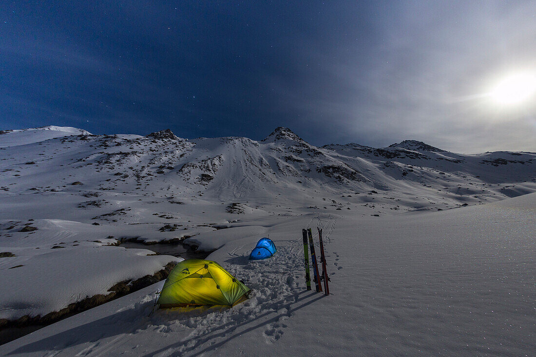 Tents light during a winter full moon night at Fluela pass - Switzerland