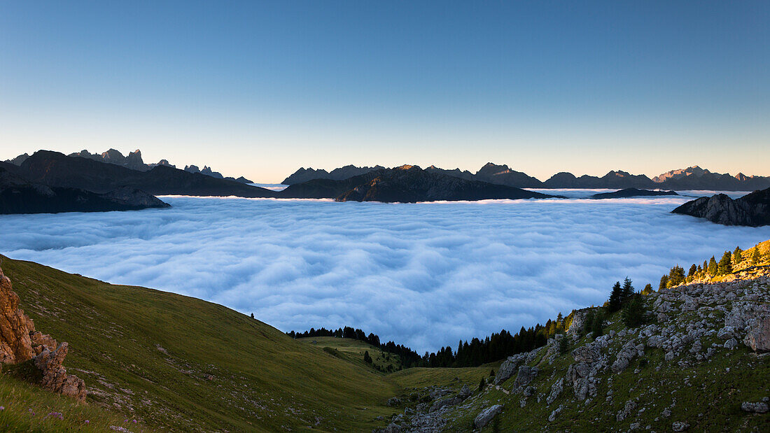 a suggestive sunrise from the Rosengarten Group with all the Fassa valley covered by clouds, Trento province, Trentino Alto Adige, Italy