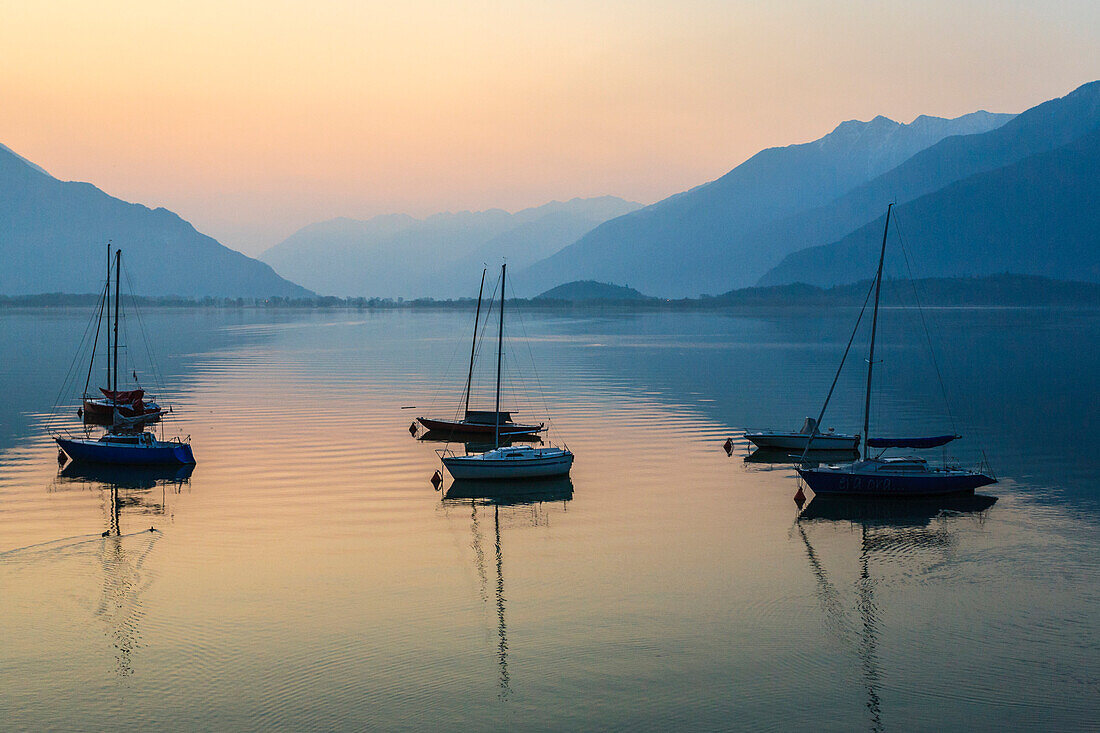 Reflected boat at sunrise at Como lake, Lombardy, italy, province of Como