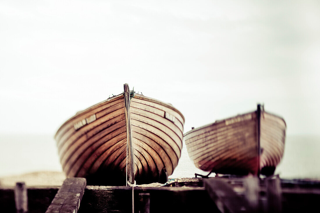 Two wooden boats sitting on the shore; England