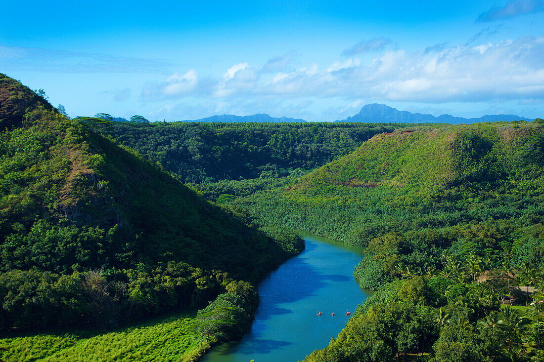 Landscape with dense, lush foliage and the tranquil, blue waters of the Wailua River; Wailua, Kauai, Hawaii, United States of America