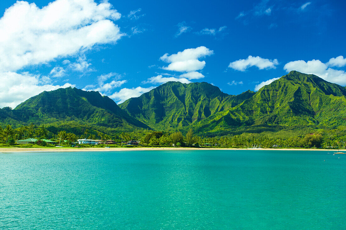 Stunning turquoise ocean water and the rugged green mountains on the island of Kauai; Hanalei, Kauai, Hawaii, United States of America