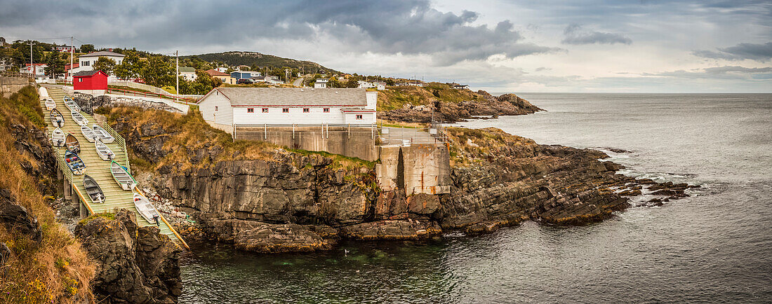 Fishing sheds and cliffs with stratum along the Atlantic coastline; Bonavista, Newfoundland, Canada