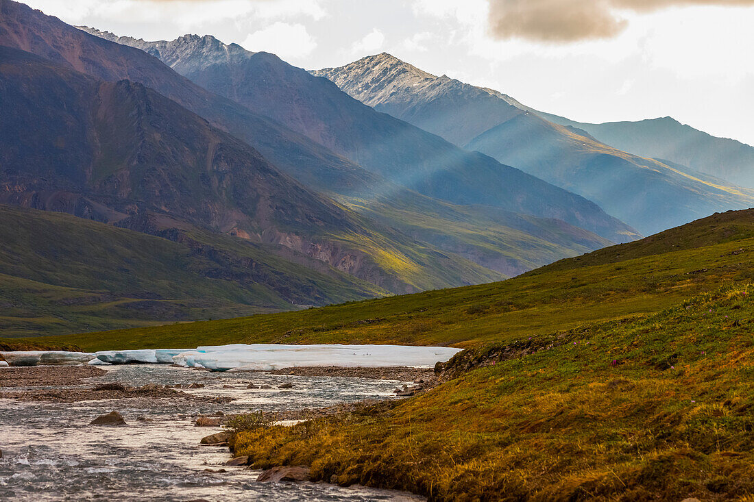 Light penetrates the clouds in a valley in the Brooks Range; Alaska, United States of America