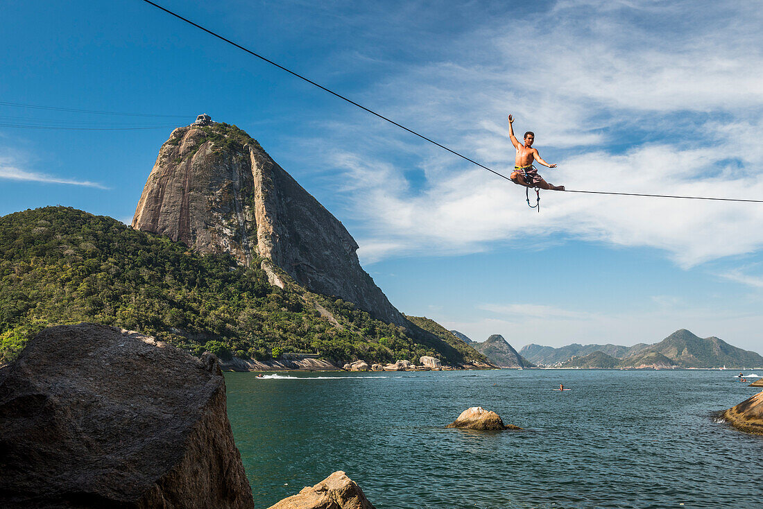 Man posing on high line in Contos De Pescadores, Vermelha Beach, Rio de Janeiro, Brazil