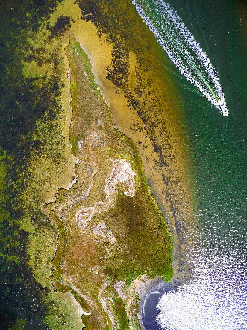 Aerial view drone of Nantucket coastline with motorboat travelling along, Massachusetts, USA