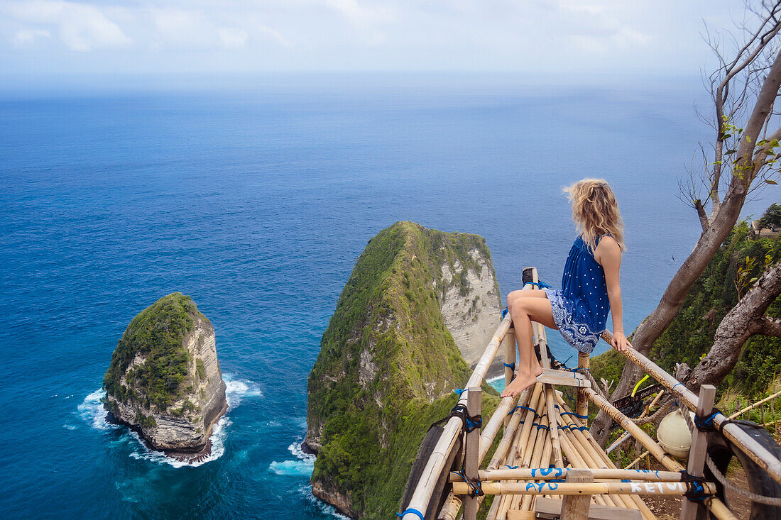 Adult woman admiring coastline of Nusa Penida island, Bali, Indonesia