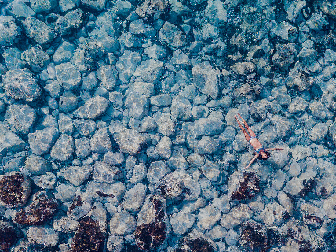 Aerial view of woman floating on clear water, Tenerife, Canary islands, Spain