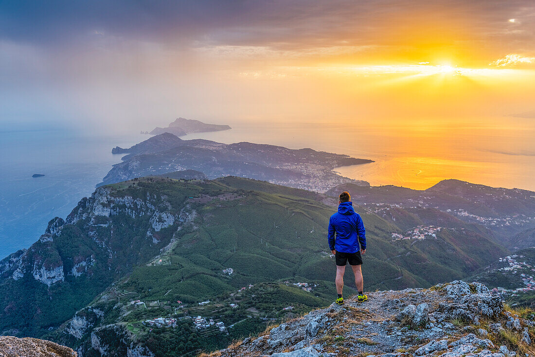 San Michele mountain, Pimonte, Napoli, Campania, Italy, Sunset over Sorrento peninsula and Capri island, A hiker admires the view