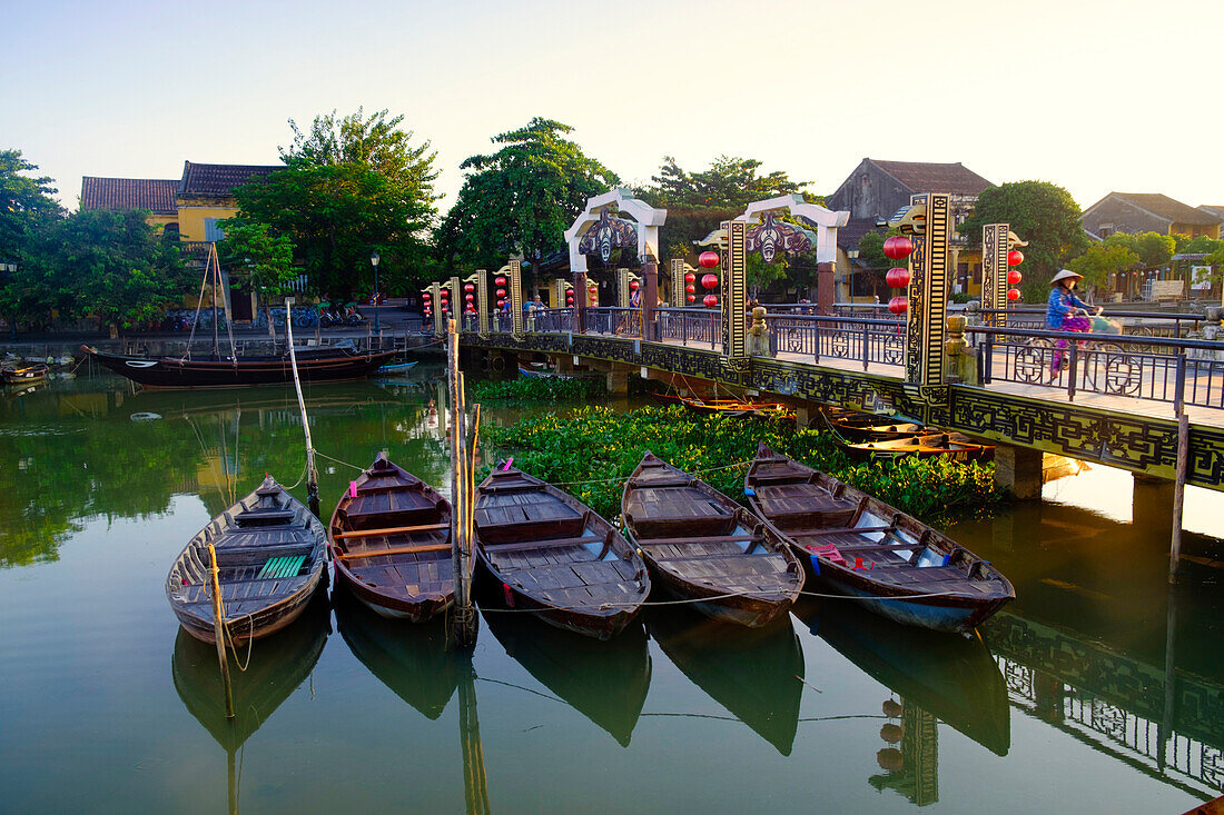 Boats on the Thu Bon River with a cyclist on the Lantern Bridge in Hoi An, UNESCO World Heritage Site, Quang Nam, Vietnam, Indochina, Southeast Asia, Asia