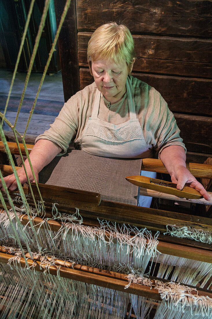 Weaver at work in 19th century house, Latvian Ethographic Open Air Museum, Riga, Latvia, Europe