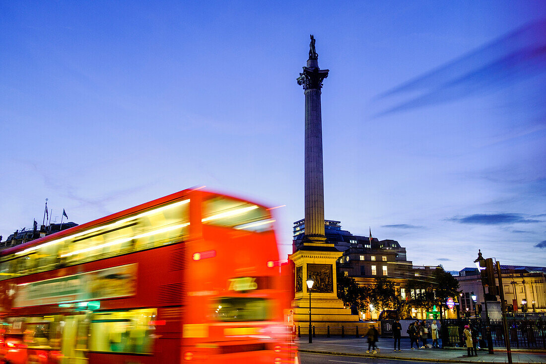 Red bus passing Nelson's Column in Trafalgar Square, London, England, United Kingdom, Europe