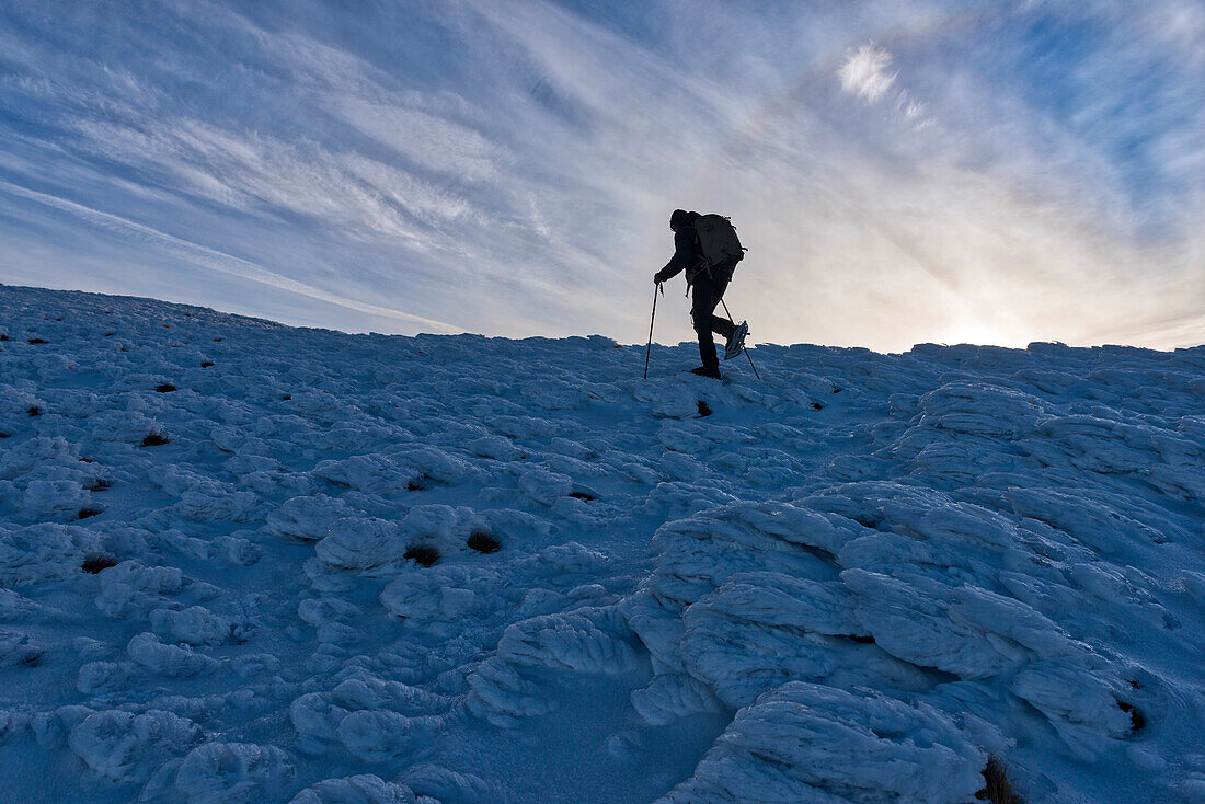 Hiker at sunrise in winter, Monte Cucco Park, Apennines, Umbria, Italy, Europe