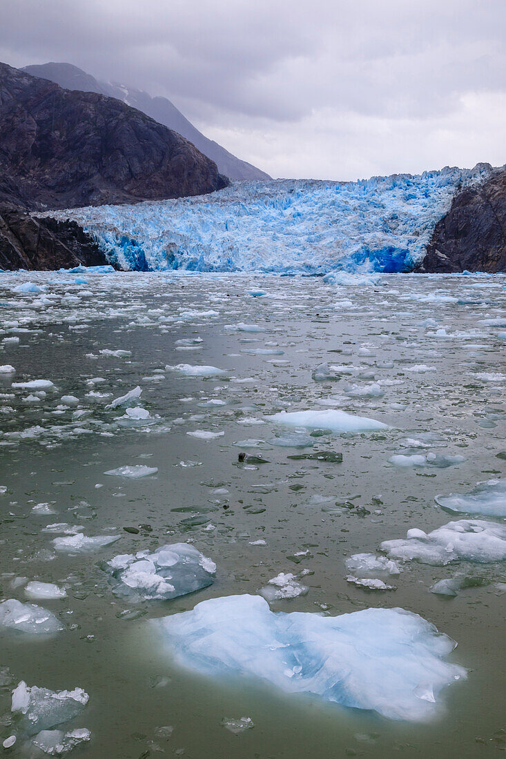 Ice pack and blue ice face of South Sawyer Glacier, mountain backdrop, Stikine Icefield, Tracy Arm Fjord, Alaska, United States of America, North America