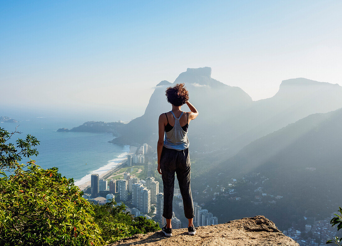 Brazilian girl looking towards the Pedra da Gavea and Sao Conrado from Dois Irmaos Mountain, Rio de Janeiro, Brazil, South America