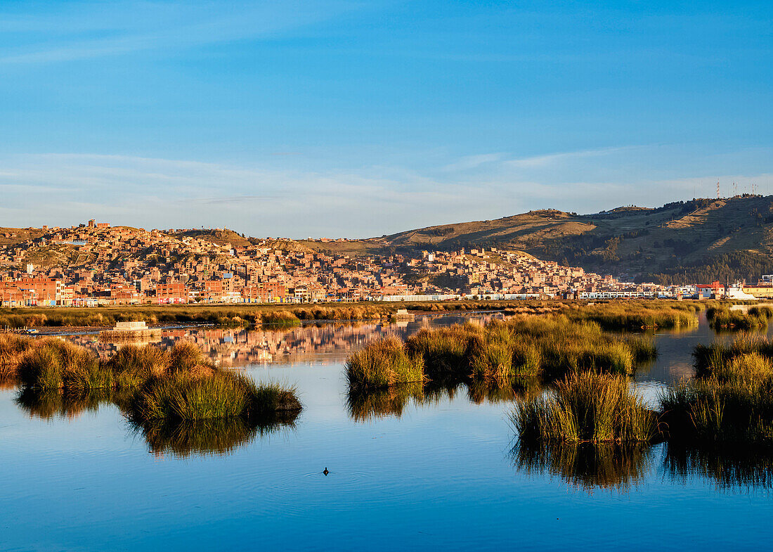 Lake Titicaca and cityscape of Puno at sunrise, Peru, South America