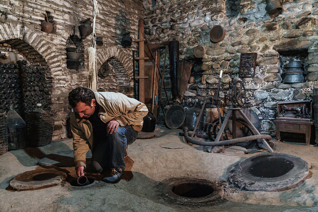 Sampling wine from underground vats, Nodari Wine Cellar, Velistsikhe, near Sighnaghi, Kakheti, Georgia, Central Asia, Asia
