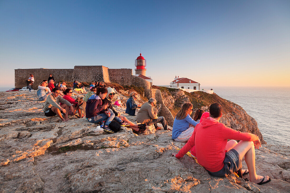 Tourists enjoying sunset at the lighthouse at Cabo de Sao Vicente, Sagres, Algarve, Portugal, Europe
