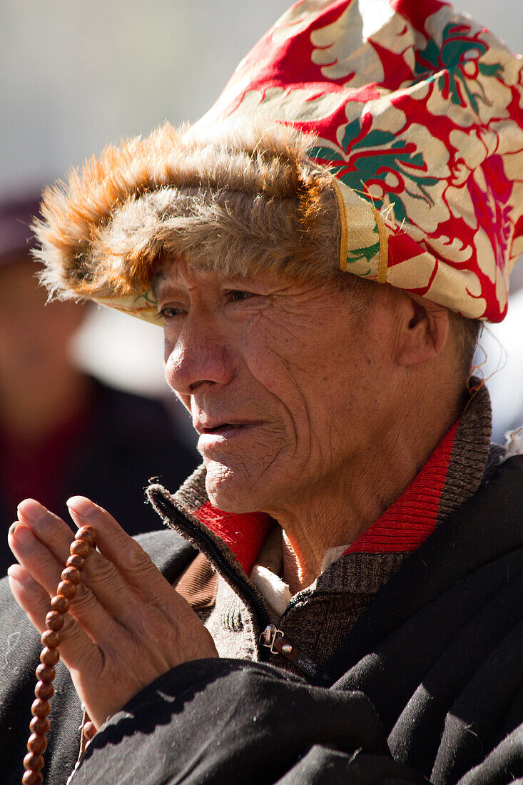 Man praying at the Jokhang Temple of Barkhor Square, Lhasa, Tibet, China, Asia