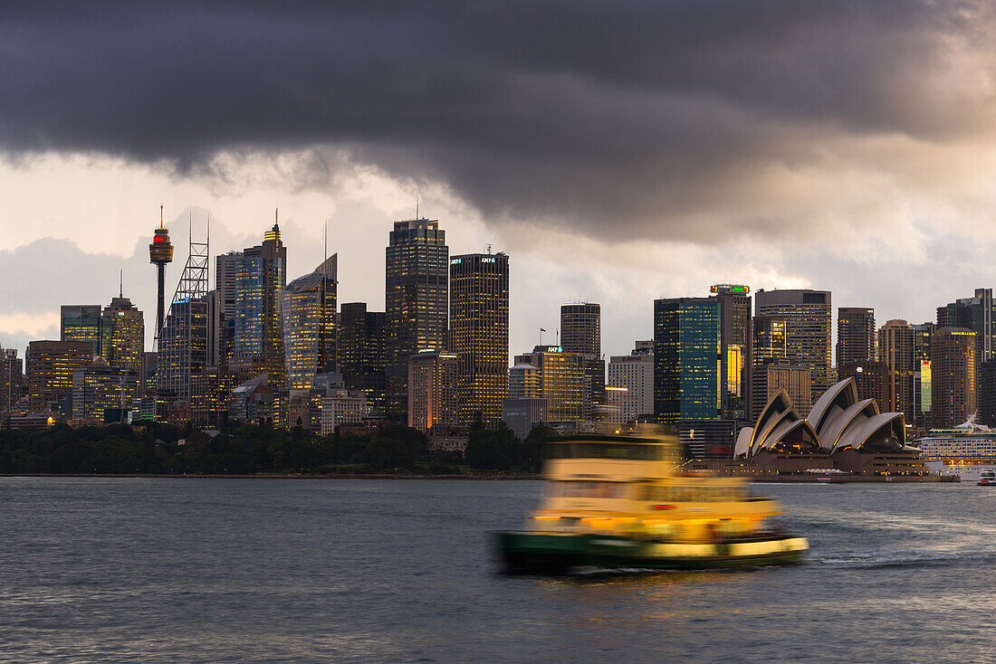 A ferry in Sydney Harbour at dusk with the Opera House and city skyline, Sydney, New South Wales, Australia, Pacific