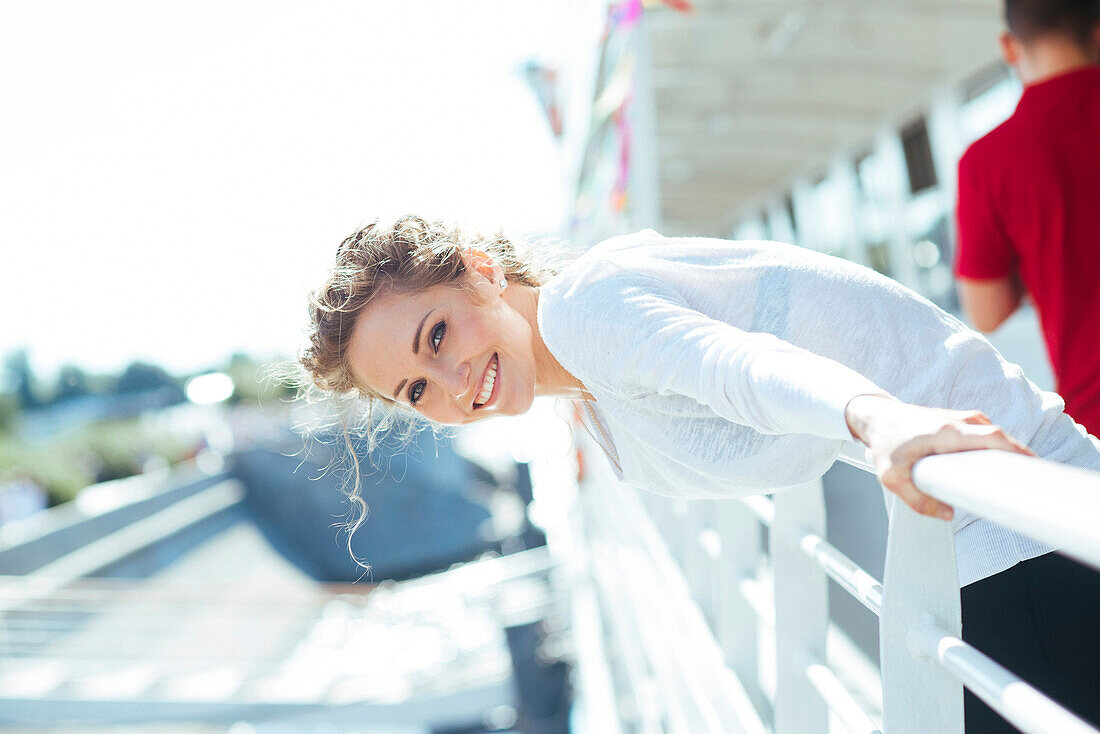 Smiling Caucasian woman leaning over railing