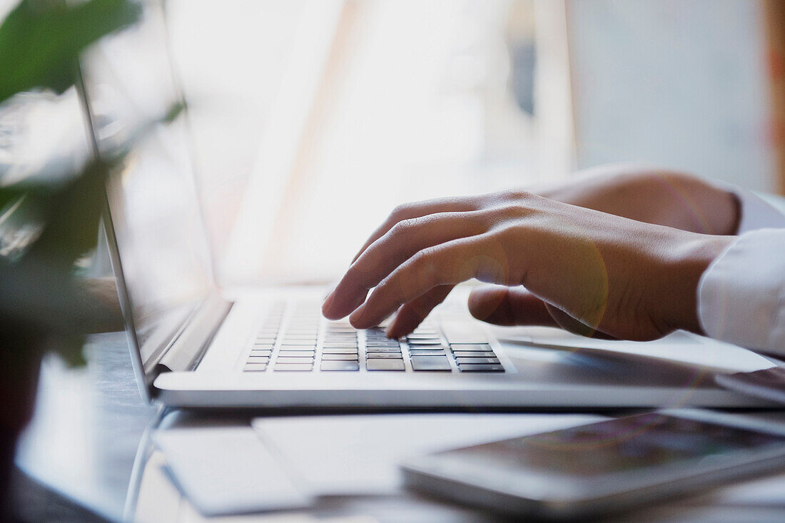 Hands of African American woman typing on laptop