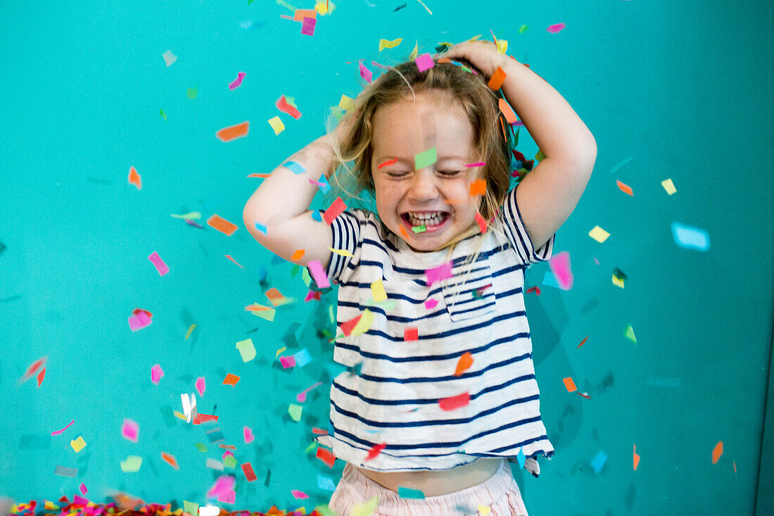 Colorful confetti falling on Caucasian girl