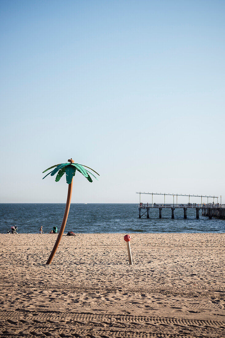 beach shower camouflaged as coconut palm tree on the beach of Coney Island, Steeplechase Pier in background, Brooklyn, NYC, New York City, United States of America, USA, North America