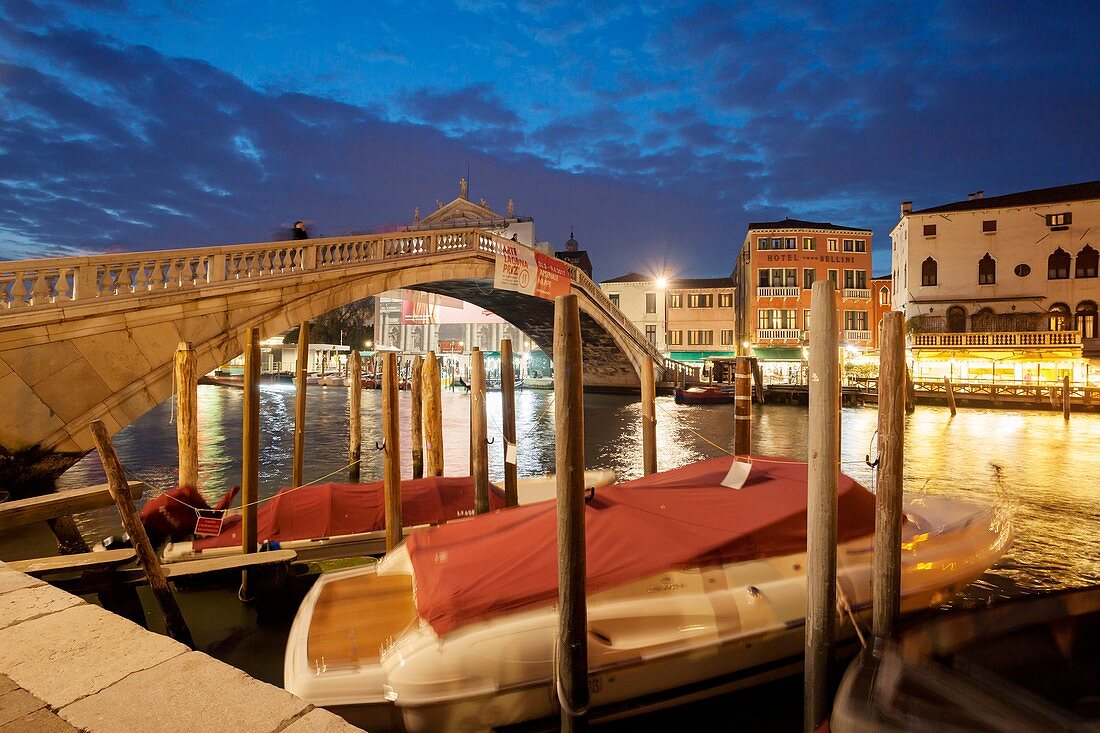 Night falls at Scalzi bridge across Grand Canal in Venice, Italy.