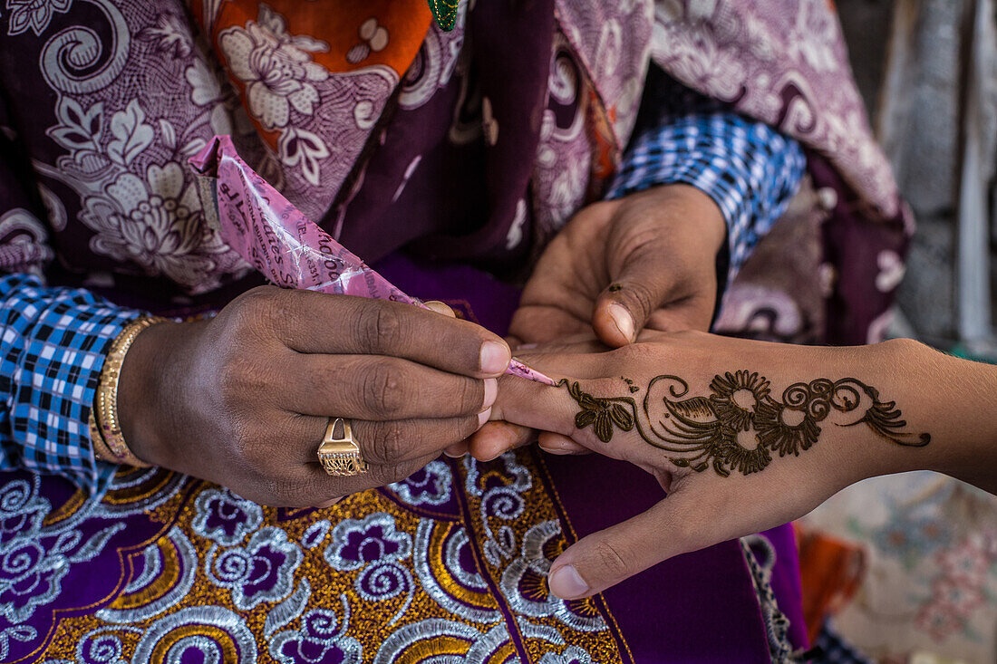 Bandari Frau mit Maske malt Henna-Tattoo, Iran, Asien
