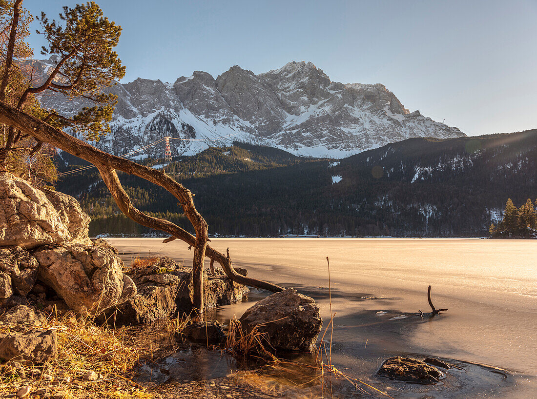 A sunny winter afternoon at the frozen Eibsee with a view of the Zugspitze and the Zugspitzbahn, Eibsee, Upper Bavaria, Germany