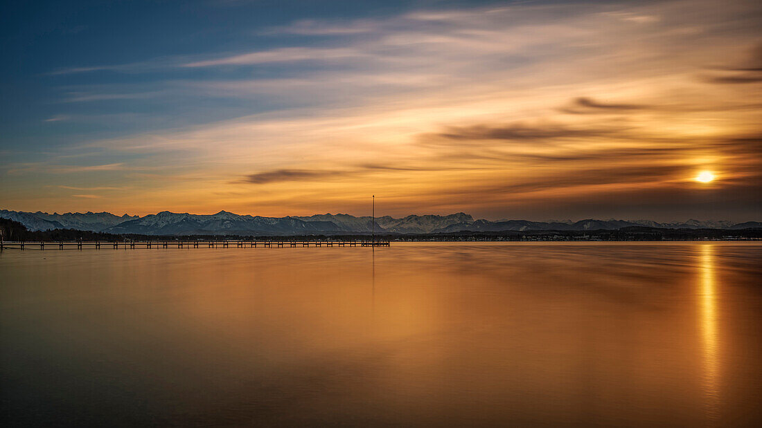Sunset on Lake Starnberg with a view of a jetty and the Wetterstein Mountains with Zugspitze, Ambach, Upper Bavaria, Germany