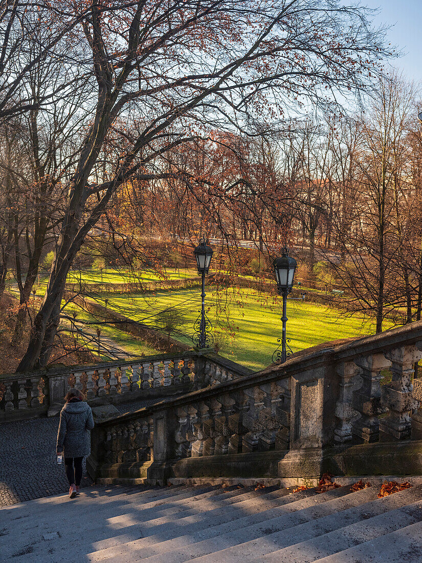 A young lady walks down the steps on Friedensengel towards the park, Munich, Upper Bavaria, Germany